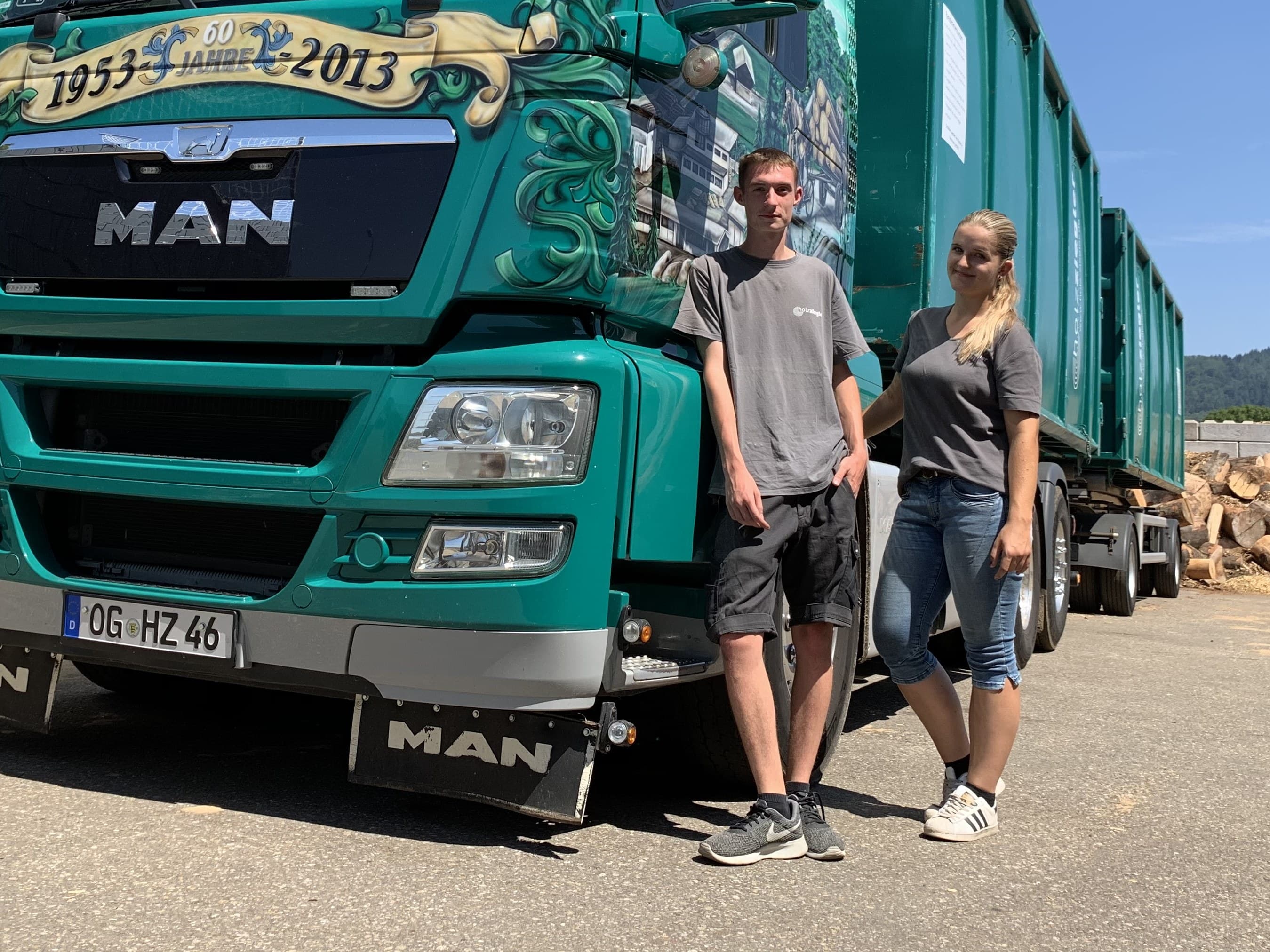 Die Auszubildenden Lena und Julian vor einem Containerzug